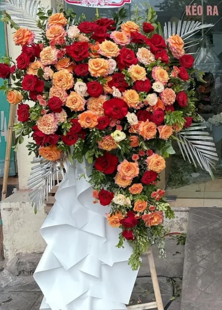 kệ hoa chúc mừng công ty đỏ cam lá cau bạc